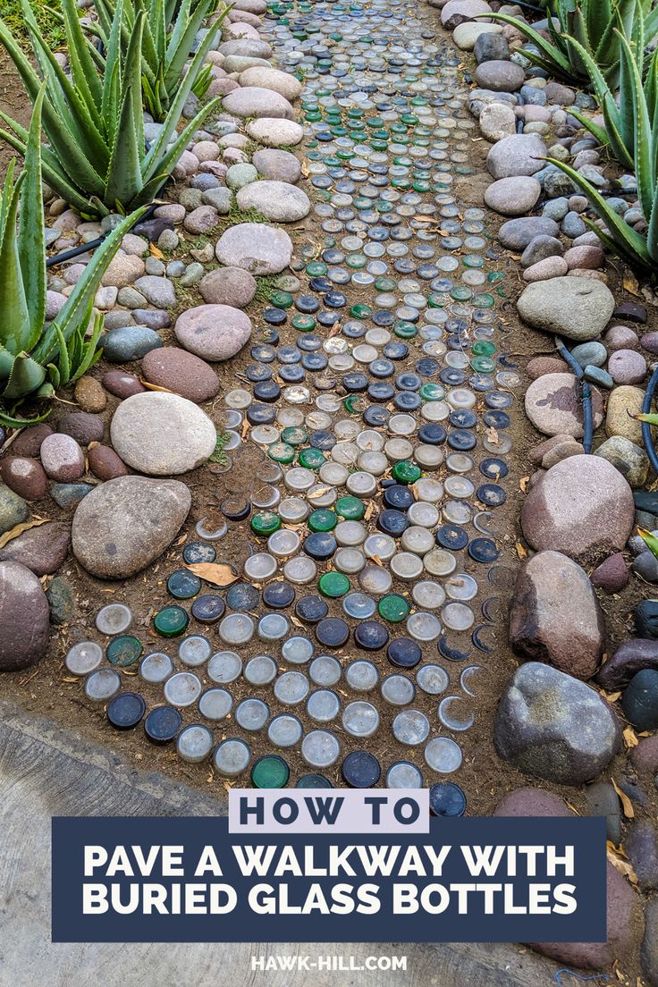 a pathway made out of rocks and pebbles with text overlay reading how to pave a walk way with buried glass bottles