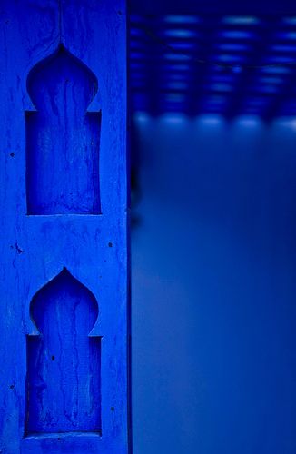 a blue door with an intricate design on the front and back sides is illuminated by light from below