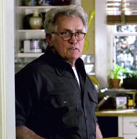 an older man standing in a kitchen next to a counter