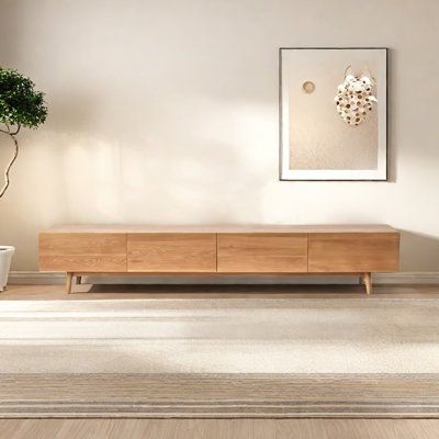 a living room scene with focus on the coffee table and potted plant in the corner