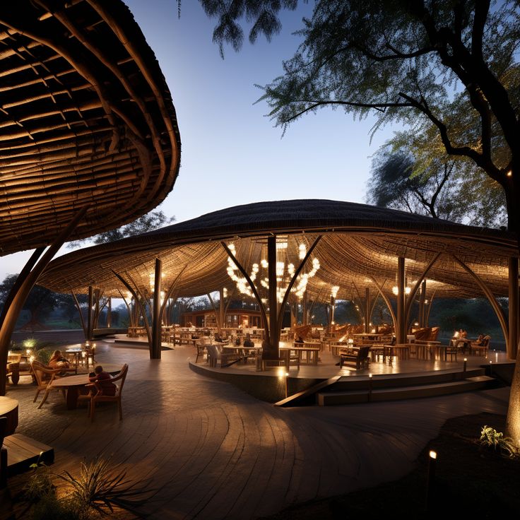 an outdoor restaurant lit up at night with lights on the tables and chairs around it