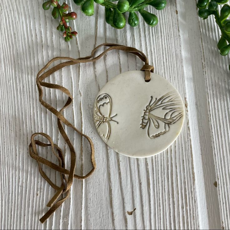 a ceramic ornament with an image of a bird on it next to some plants