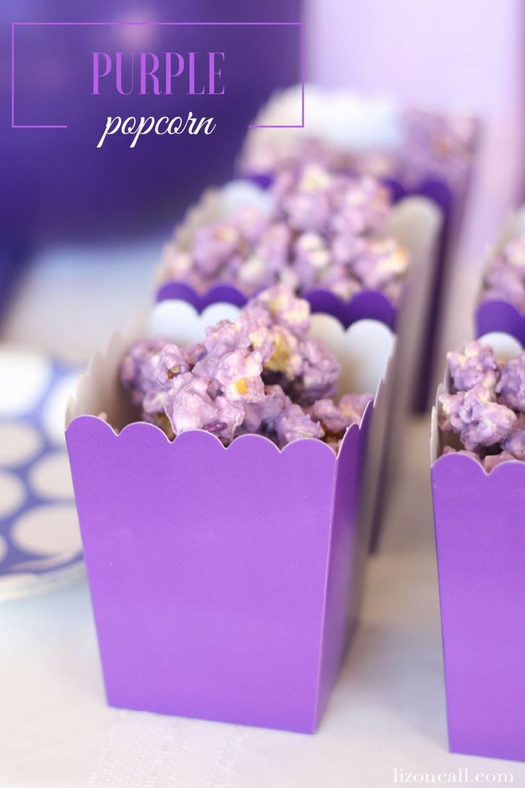 purple popcorn sitting in small boxes on a table