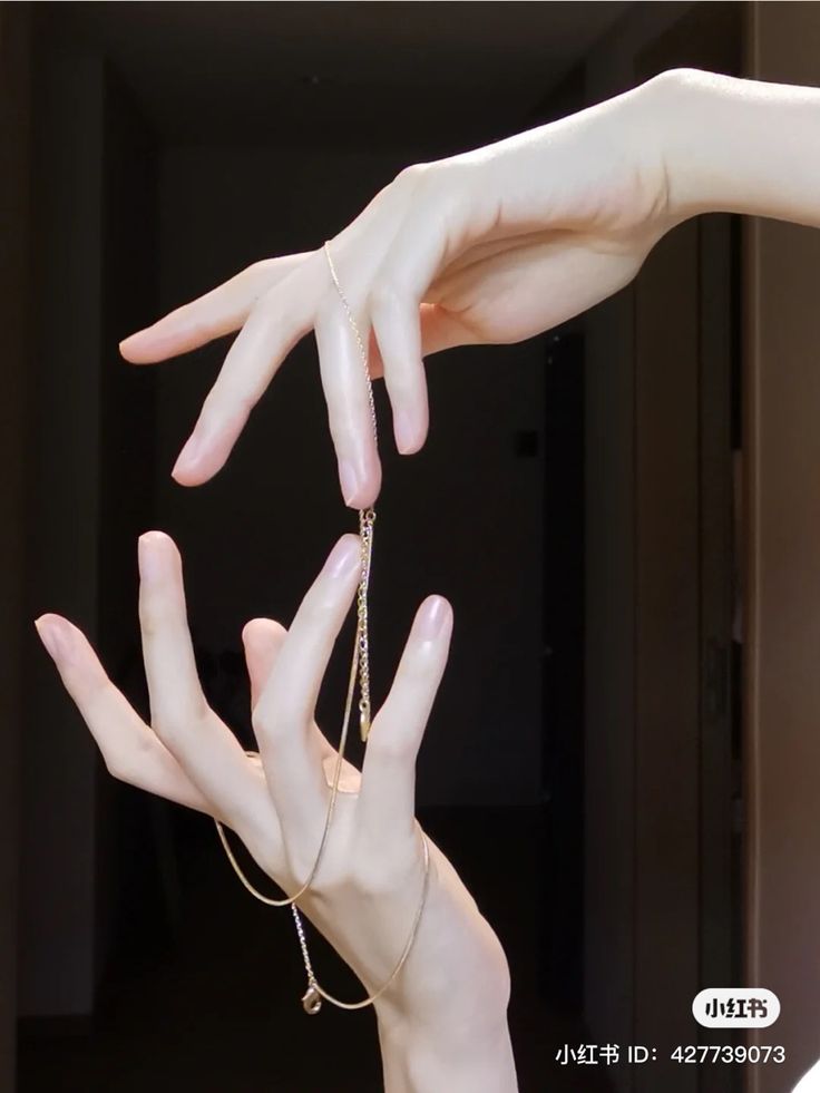 two hands reaching out to each other with chains on their fingers, in front of a door