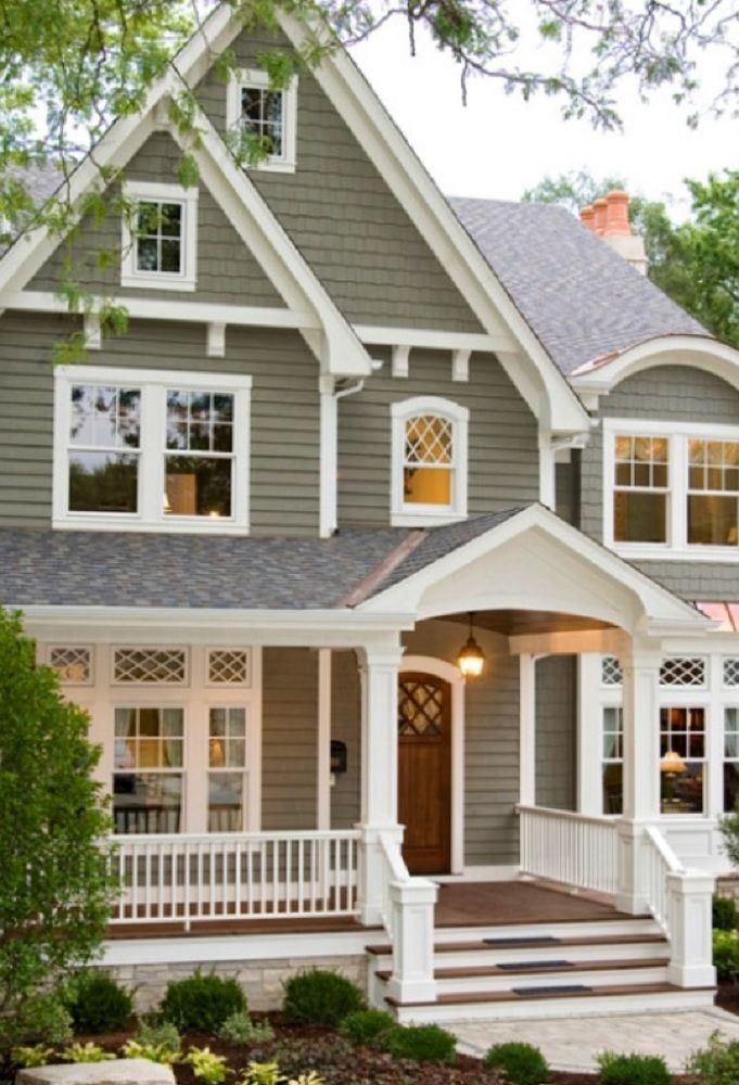 a gray house with white trim on the front porch and steps leading up to it