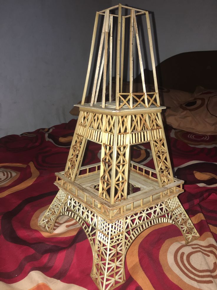 a golden metal tower sitting on top of a bed