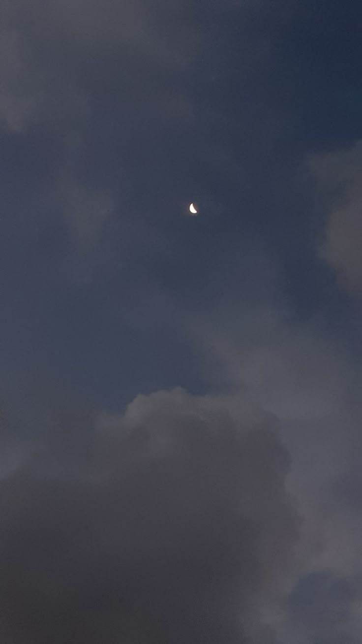 the moon is shining in the cloudy sky