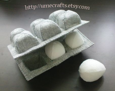 an egg carton filled with four eggs on top of a wooden table next to a computer mouse