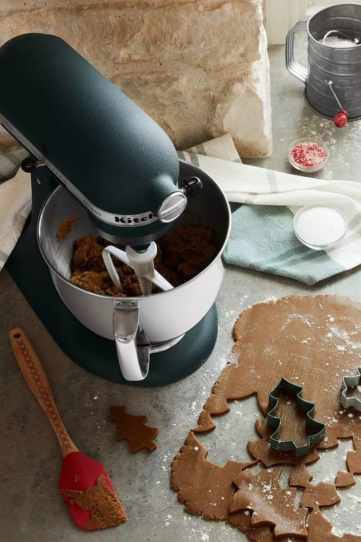 a mixer with ginger cookies in it on a table next to cookie cutters and utensils