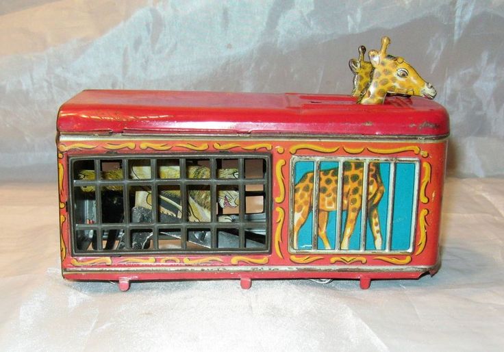 a giraffe figurine sitting on top of an old fashioned toy radio