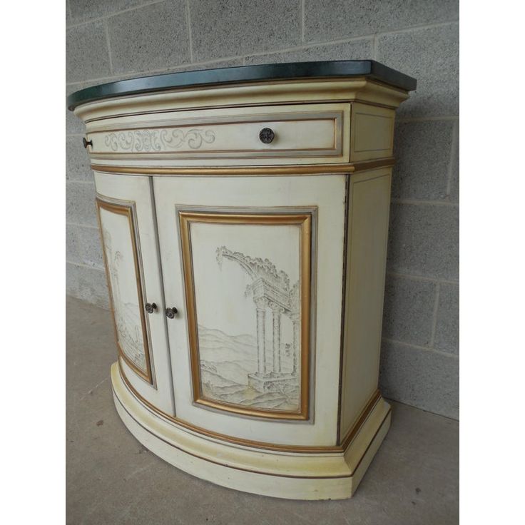 an ornate painted cabinet on display in a room with brick wall and tile flooring