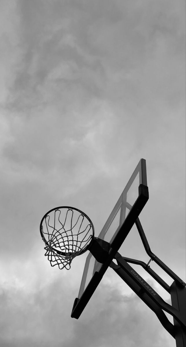 a basketball hoop is in the air against a cloudy sky with some clouds behind it