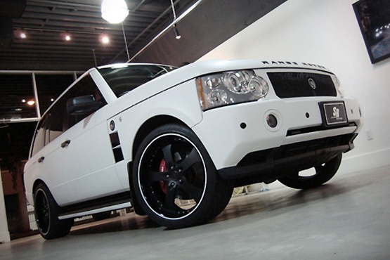 a white suv parked in a garage next to a wall