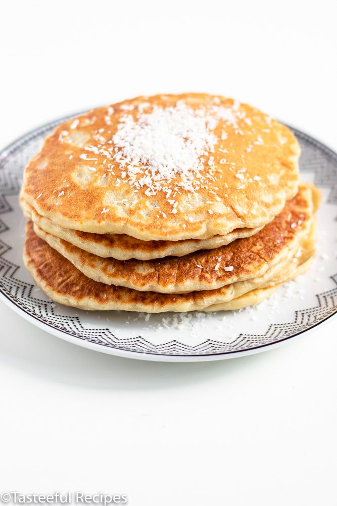 three pancakes on a plate covered in powdered sugar