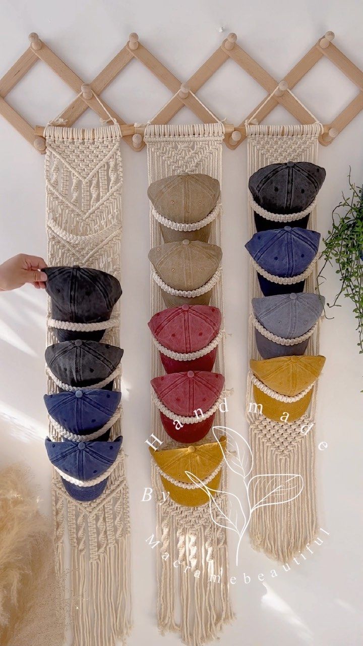 several hats are hanging on a wall with macrame hooks and string attached to them