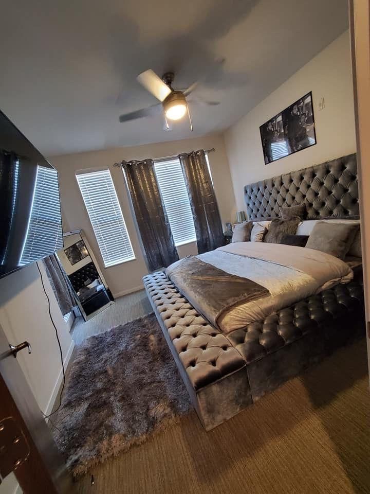 a bedroom with a large bed and ceiling fan