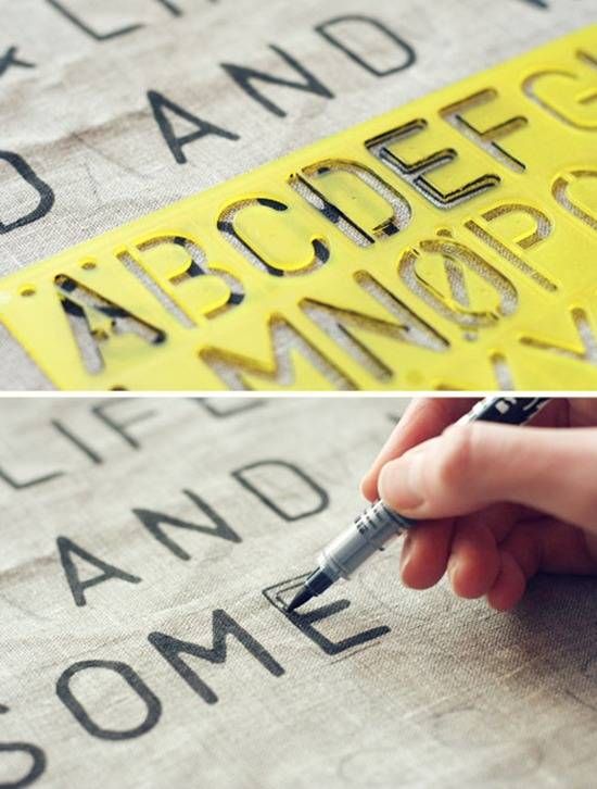 someone is using scissors to cut out the letters on a piece of fabric that reads,