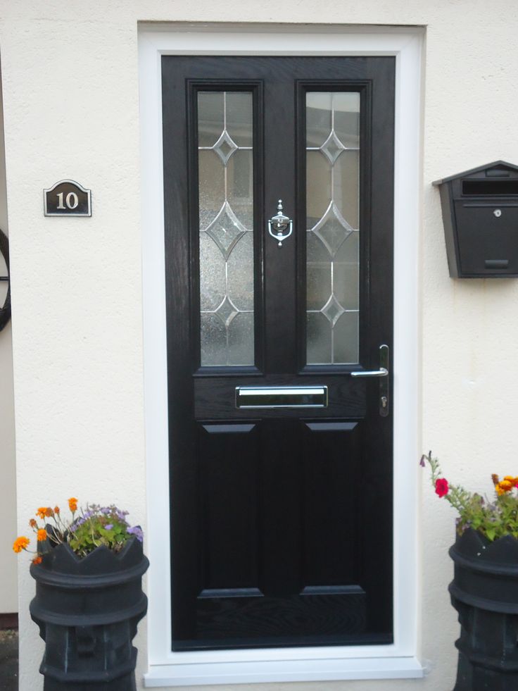 a black front door with two planters on either side