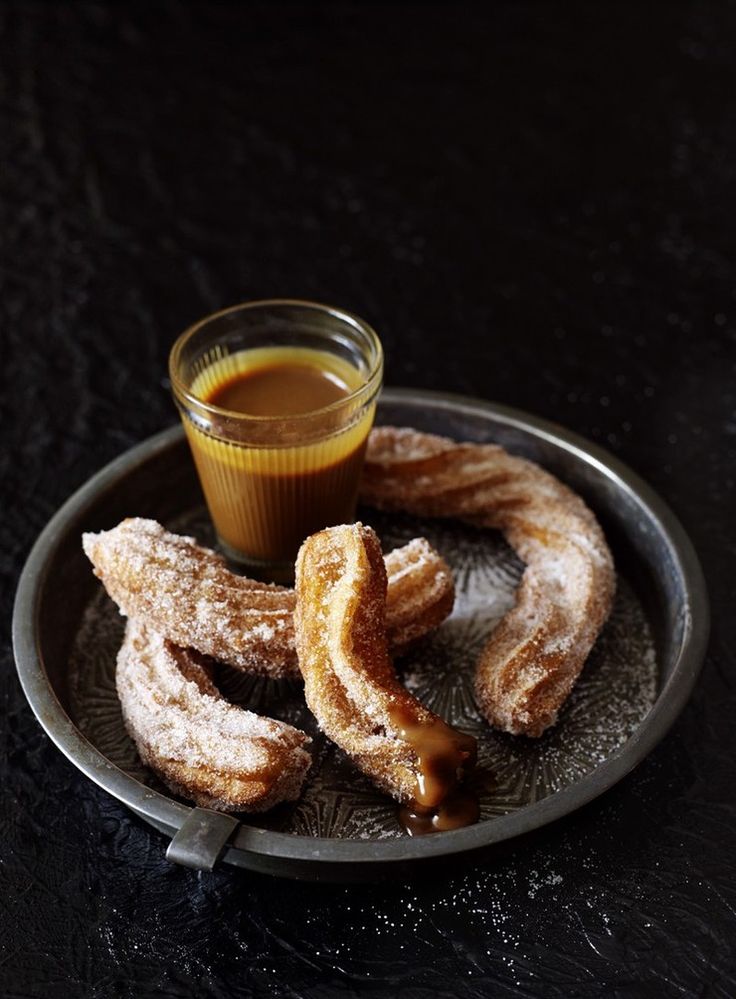 a plate with churros and a glass of orange juice