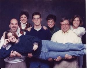 a group of people are posing for a photo with one person on the back of another