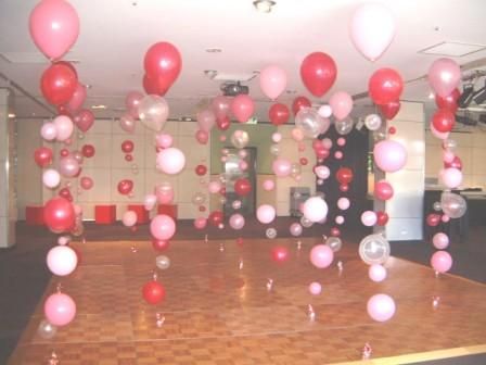 pink and white balloons are floating in the air on a dancefloored floor