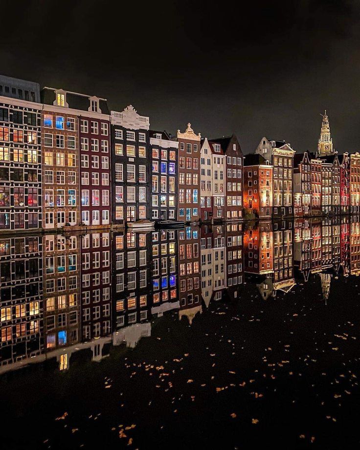 many buildings are reflected in the water at night