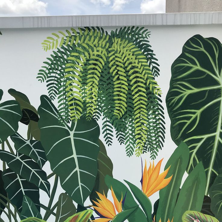 a large mural on the side of a building with tropical plants and leaves painted on it