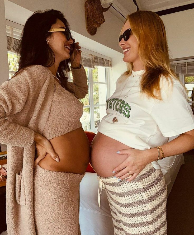 two pregnant women standing next to each other