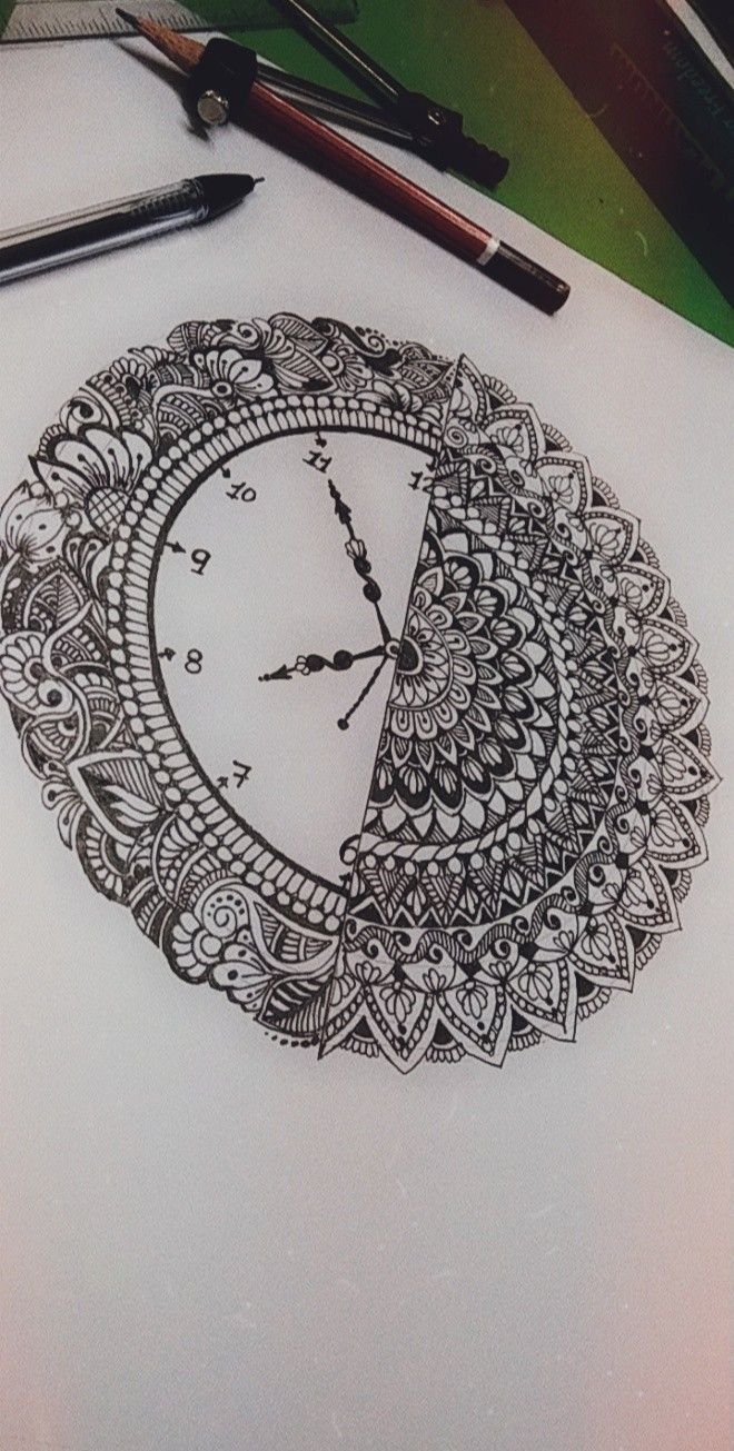 a drawing of a clock that is drawn on paper with markers and pencils next to it