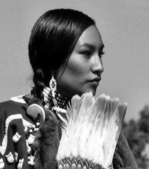 a native american woman with feathers in her hand