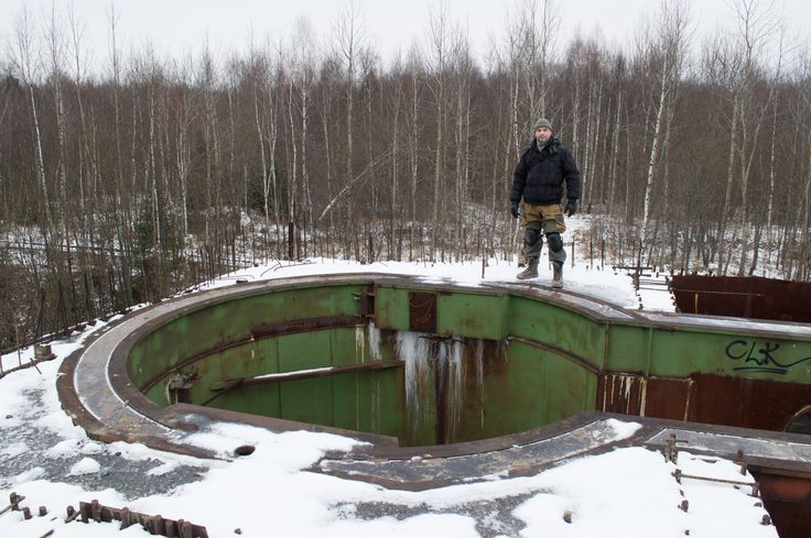 a man standing on top of a green structure in the middle of snow covered ground