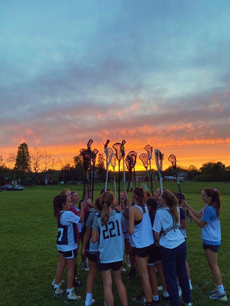 the girls lacrosse team huddles together before their match against each other at sunset