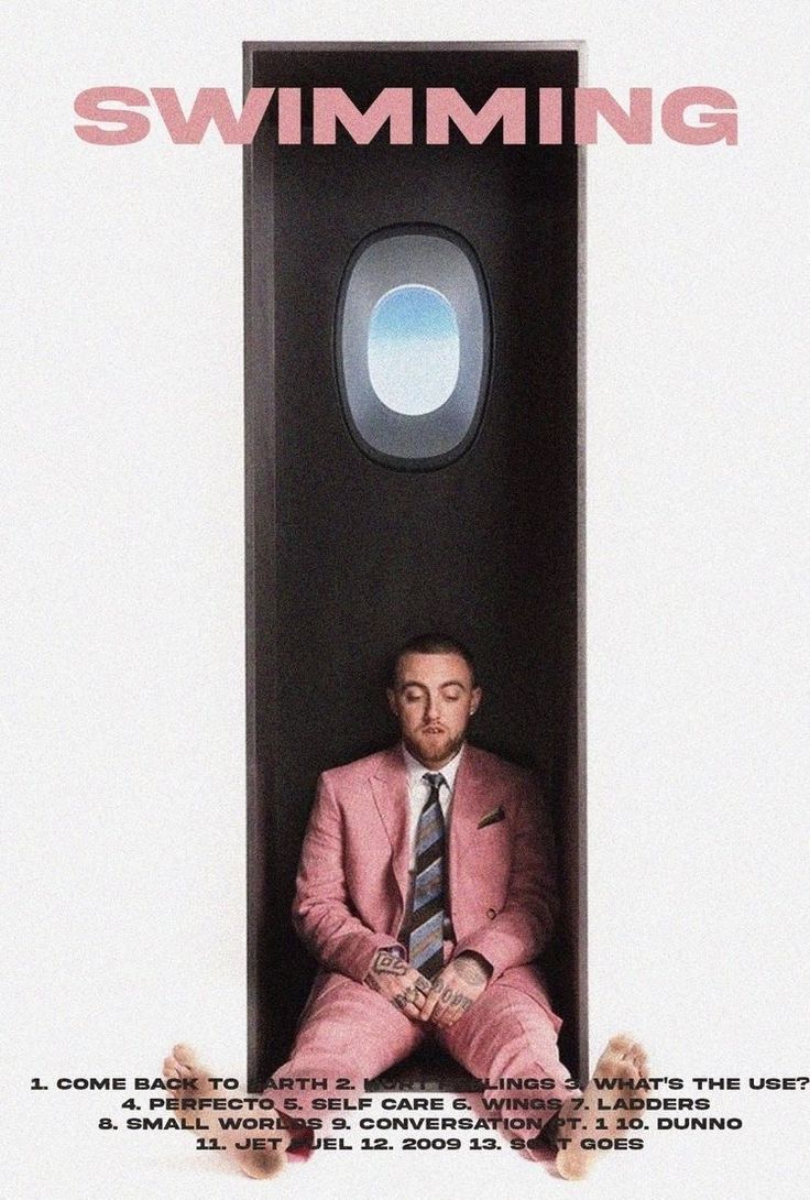 a man in a pink suit and tie sitting on the floor next to an airplane window