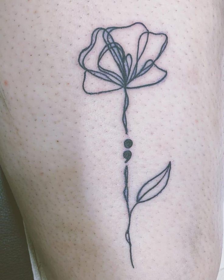 a small flower on the side of a woman's thigh with dots and lines