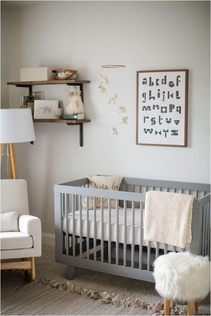 a baby's room with a crib, chair and pictures on the wall