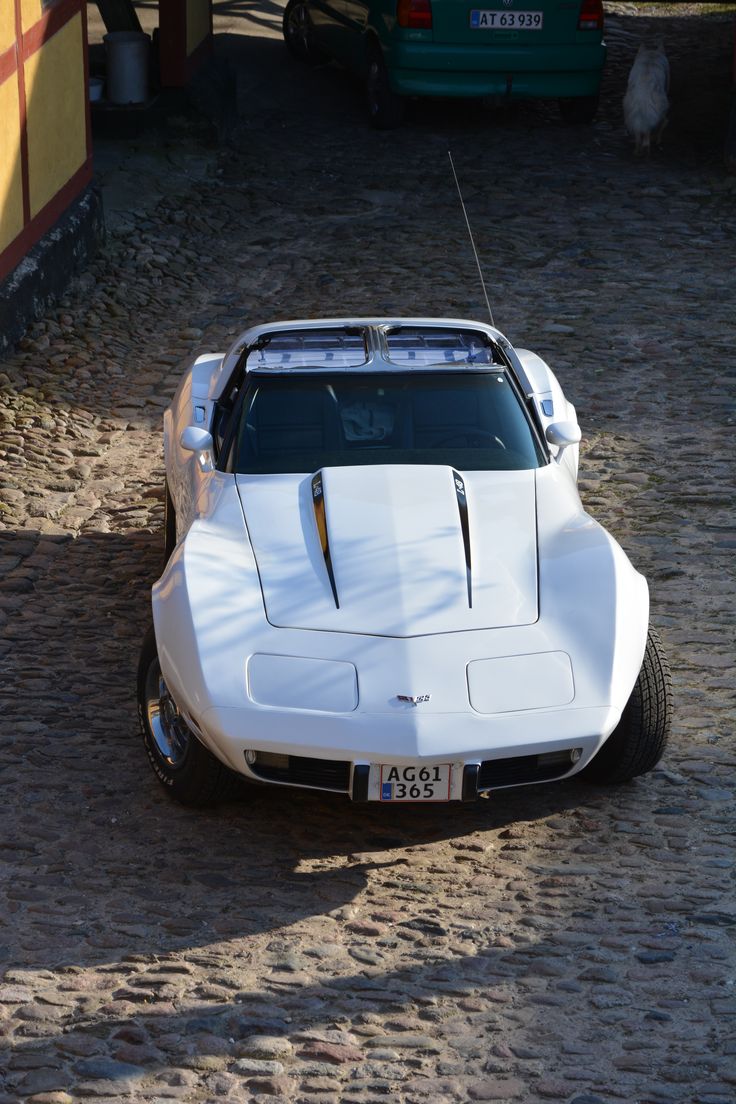 a white sports car parked in the dirt