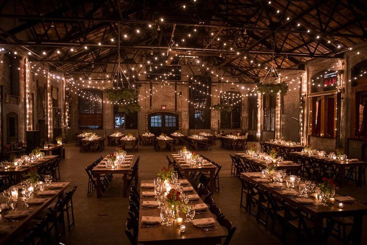 an indoor dining area with lights strung from the ceiling and tables set up for dinner