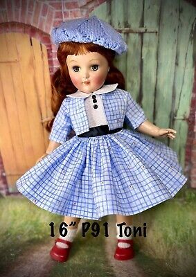 the doll is wearing a blue dress and hat