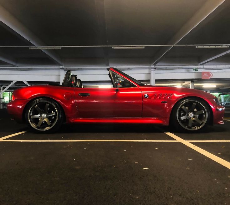 a red sports car parked in a parking garage