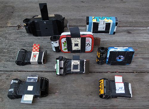 many different types of cameras sitting on top of a wooden floor next to each other