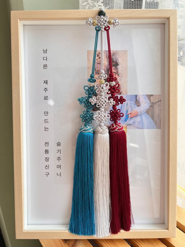 three tassels are hanging in a frame