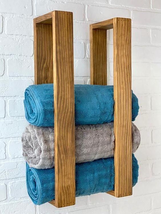 two wooden shelves holding towels in front of a brick wall