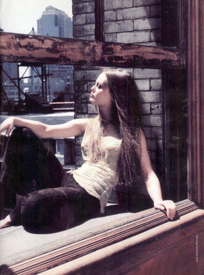 a woman sitting on top of a window sill