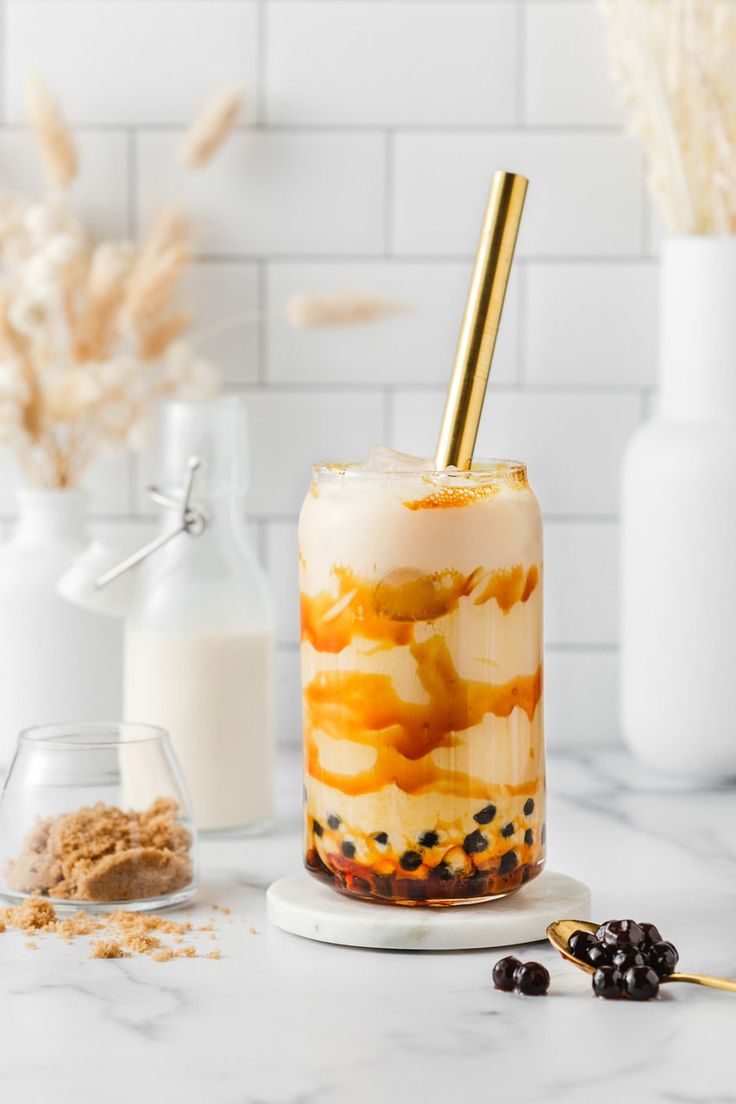 two glasses filled with dessert on top of a white counter