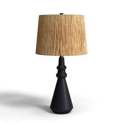 a black table lamp with a beige shade