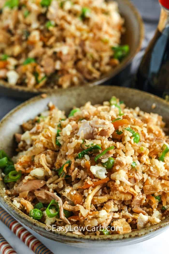 two bowls filled with rice and vegetables on top of a table