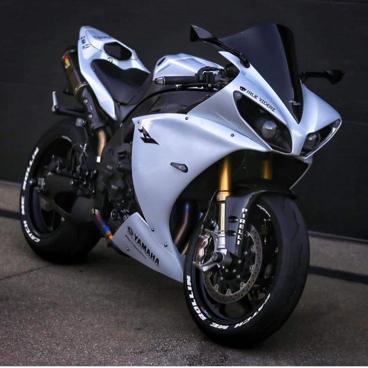 a silver and black motorcycle parked in front of a garage