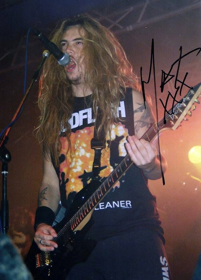 a man with long hair playing an electric guitar