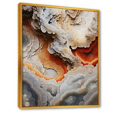 an abstract painting in gold frame on the wall with white clouds and orange hues