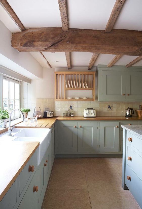 a kitchen with green cabinets and white counter tops in an old - fashioned style home